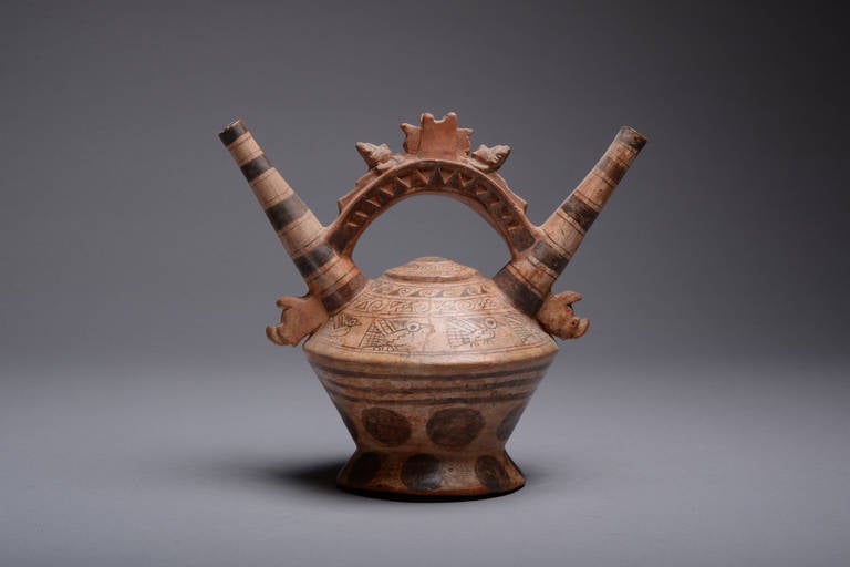 A Pre-Columbian Lambayeque-Chimu culture double spout vessel, dating to 700–1200 AD.

This footed vessel has three sharply divided sections; a ring base, body with a sharp ridge at the shoulder and two long, tapered spouts with an arched bridge