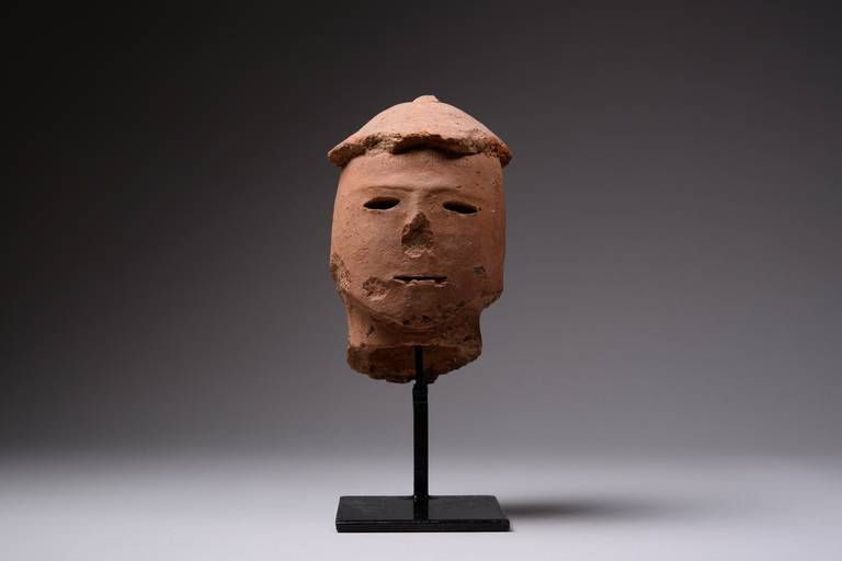 A rare Proto-Historic Japanese Haniwa bust of a man, dating to the Kofun (or Tumulus) Period, 4th-6th century AD.

The terracotta sculpture is of a male warrior, shown wearing conical helmet. He is depicted with oval face, mild brow, cut-out eyes