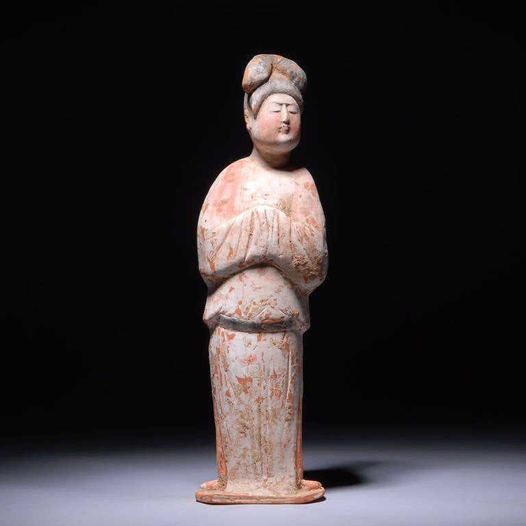A beautiful ancient Chinese Tang dynasty pottery figure of a lady, dating to 740-780 AD.

This stunning piece reflects the idealized beauty of the high Tang period. Standing facing, her sensitively modeled face has a natural beauty and charm