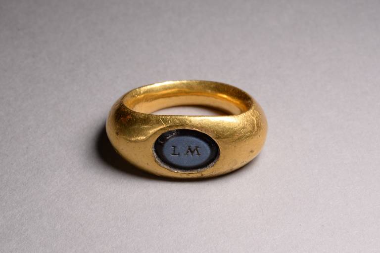 A fine Roman solid gold and nicolo intaglio finger ring, dating to the 2nd century AD.

The solid gold hoop is oval in section, with broad shoulders narrowing slightly to complete the band, which is subtly curved on its interior.  The oval bezel