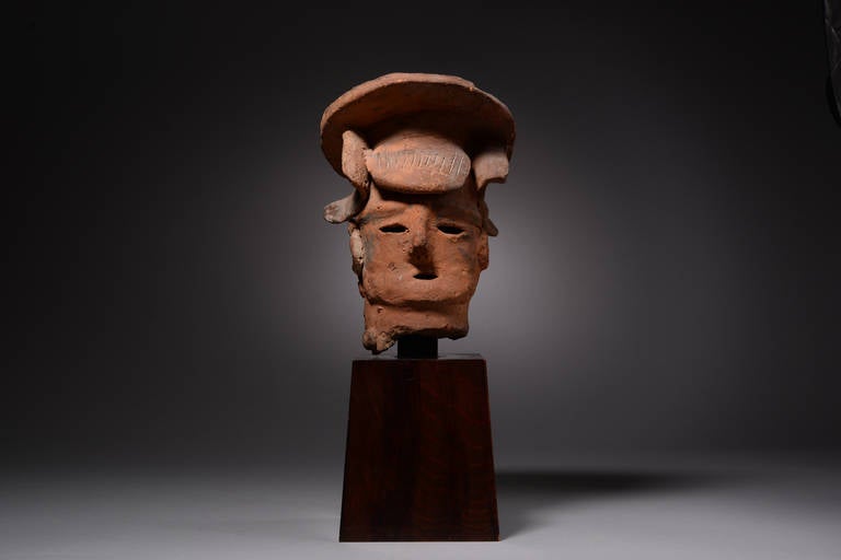 A rare proto-historic Japanese Haniwa head of a woman, dating to the Kofun (or Tumulus) Period, 4th - 6th century AD.

Rarer than Haniwa depictions of male figures, this piece shows a female in ornate attire.  This lady is shown with a wide, flat