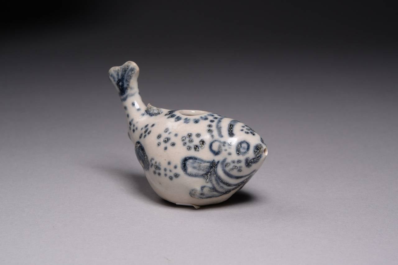A finely painted and preserved antique water dropper, officially salvaged and recorded from the famous Hoi An hoard shipwreck, dating to around 1450 AD. 

This charming little water dropper is modelled in the form of a plump puffer fish. The body