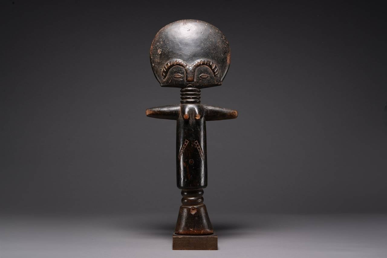 An Asante wooden aku’aba fertility doll, published as part of the Ladislas Segy collection and dating to the early 20th century.

The aku’aba of stylized form, a cylindrical torso with raised navel, breasts and distinctive scarification beneath