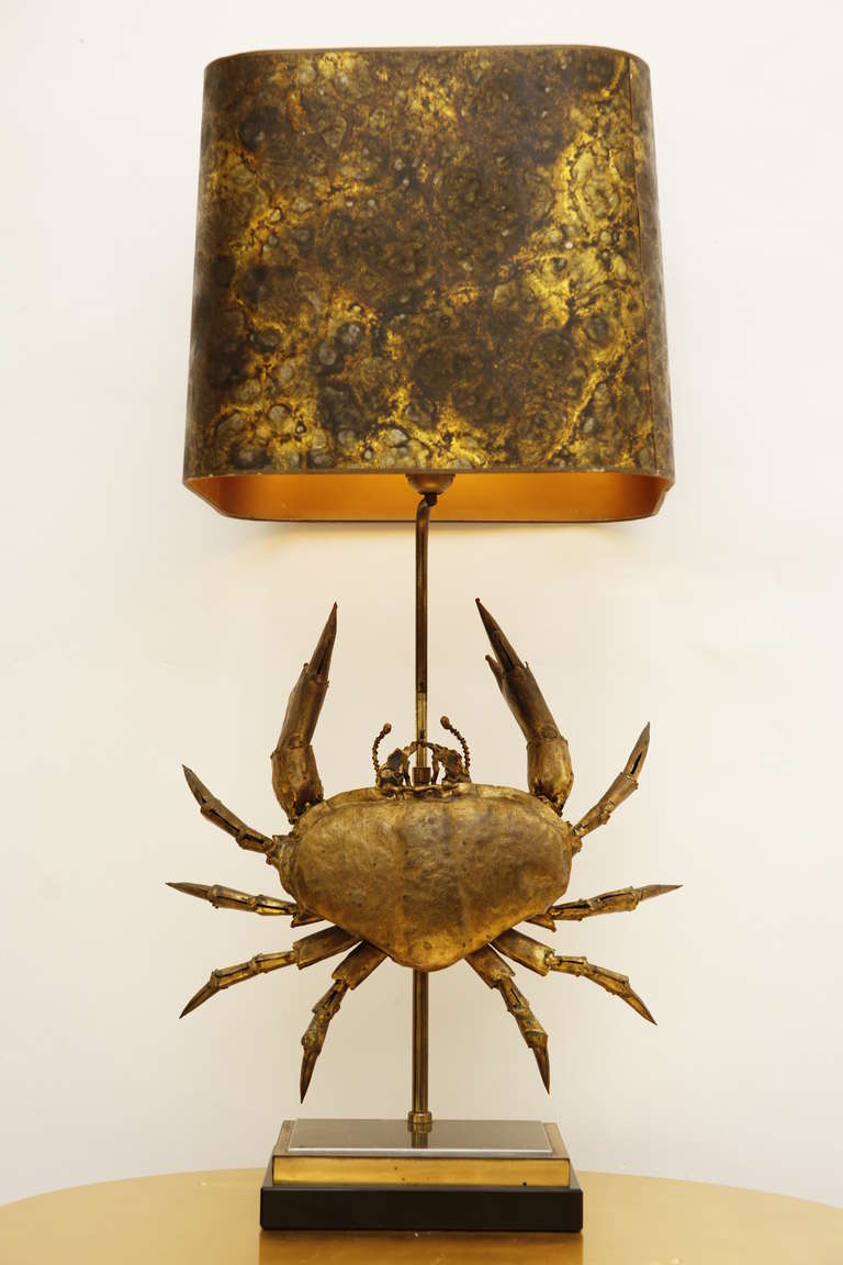 A sculpture forming a Crab mounted in embossed gilded metal table lamp. Signature on one of its pincer. 

We can electrify this lamp with U.S. standard.