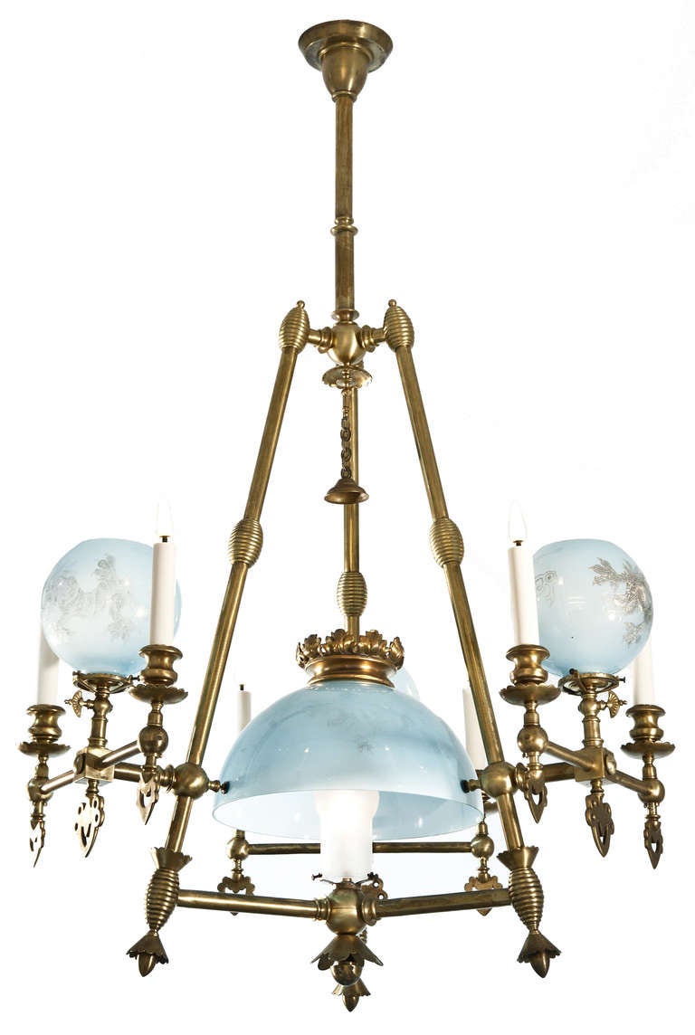 A chandelier with three arms of light with blue glass decorated with dragons.