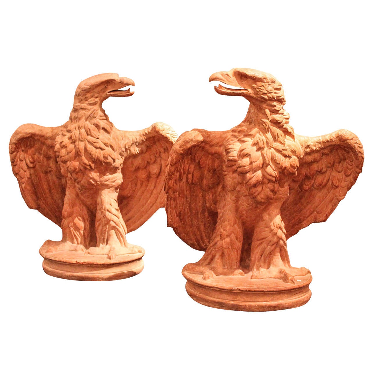 Pair of large-scale terracotta eagles, each facing each other or away and poised to take off while perched on an oval base of the same material. Highly detailed and fully realized from all angles.