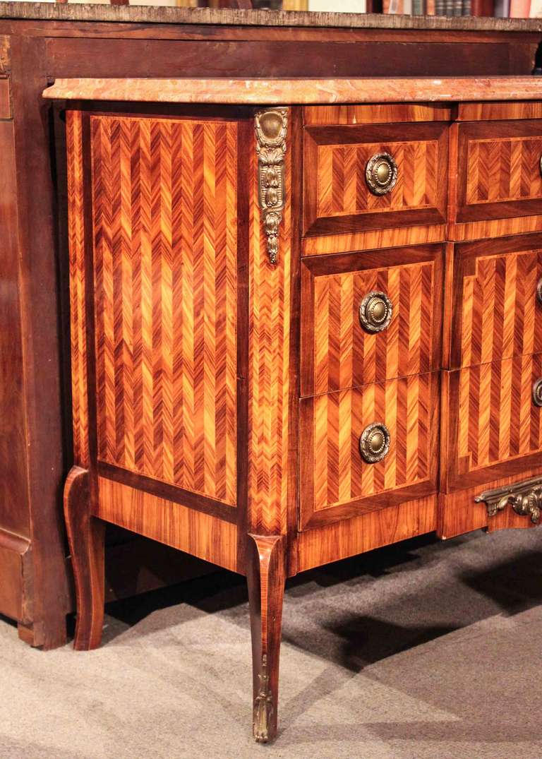 Early French transitional commode with kingwood marquetry and decorative bronze mounts. Three on two large drawers with marble top.
35