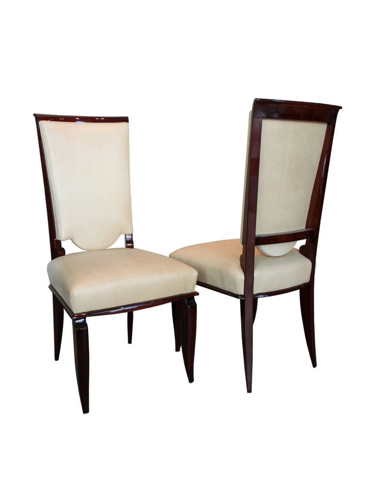 French Art Deco inlaid dining room table and set of six upholstered chairs. Table is designed with extendable arms on each end to house leaves and seat an additional four guests. Leaves not included.

Accentuated with original polished-brass
