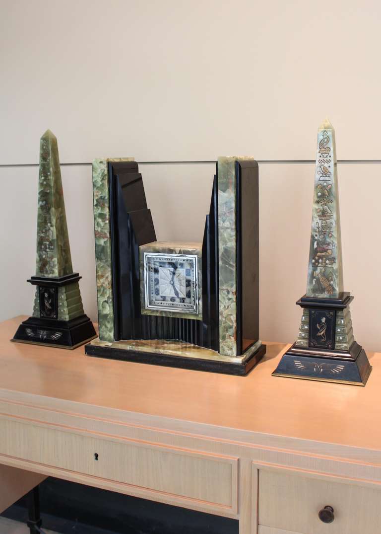 Art Deco Egyptian Revival clock and obelisk set by the electric clock manufacturer ATO of Besançon, France. Emerald marble over black onyx body with square chromed bezel and highly stylized face. Stunning combination of Egyptian inspired