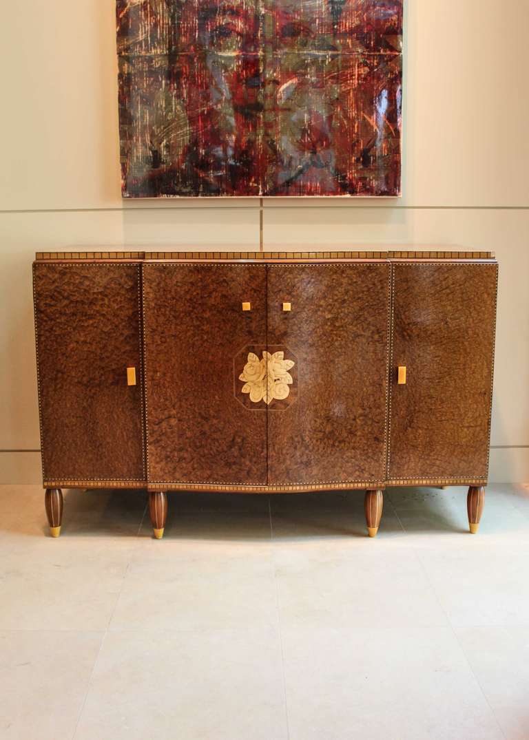 Burled bedroom cabinet with floral inlay, signed Widdicomb, circa 1945. Six drawers enclosed with four doors, two decorated with a rose motif contrasting veneer. Original hardware and bakelite drawer pulls, note the small chip in the veneer at the