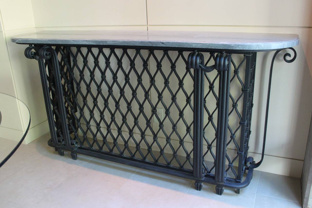 French console attributed to Gilbert Poillerat. Wrought iron base in with a woven lattice pattern with original grey marble top.