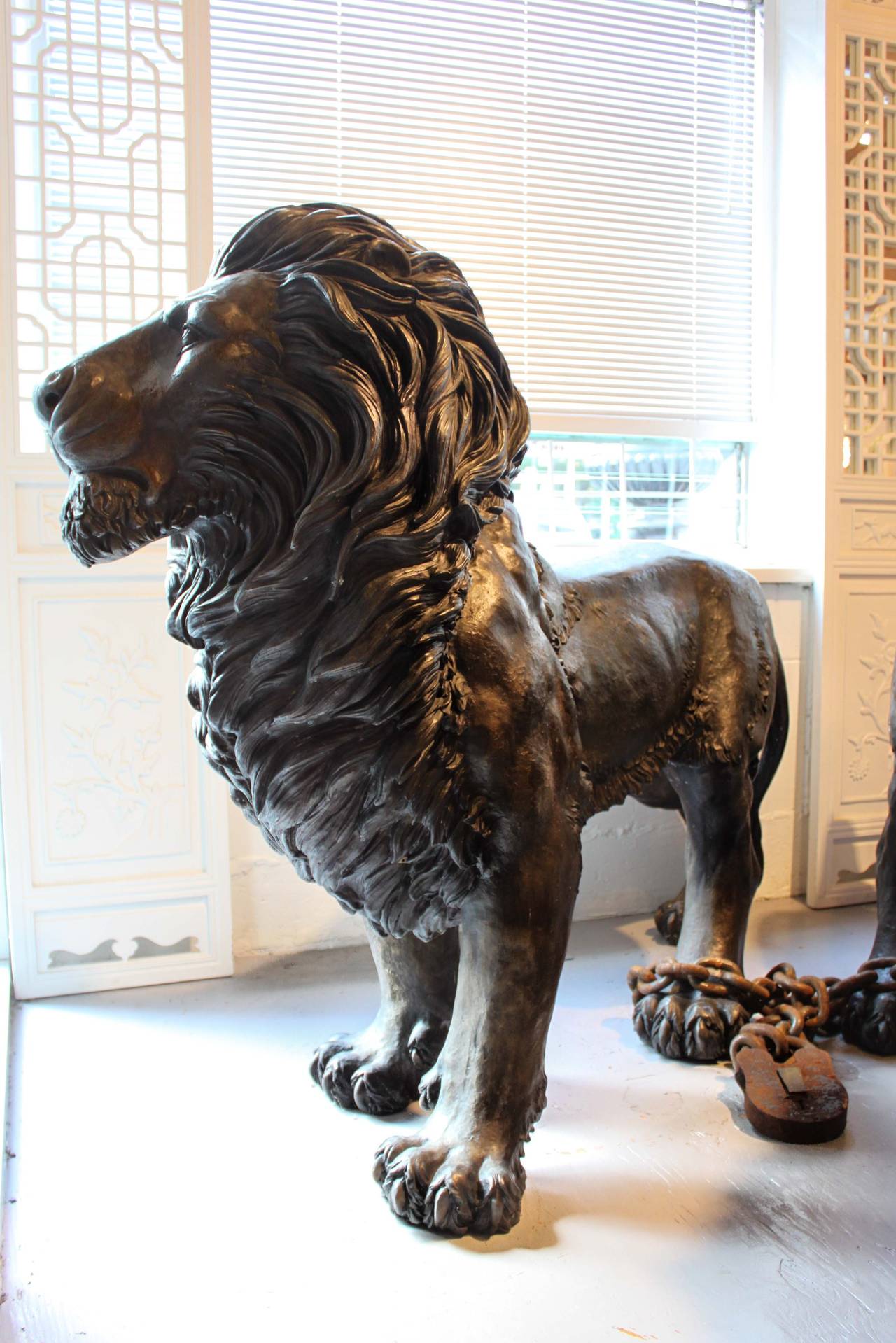 Pair of beautifully cast life-size bronze lion sculptures. Fully detailed mane and body with a proud stance and gentle facial expressions. Wonderful patina.