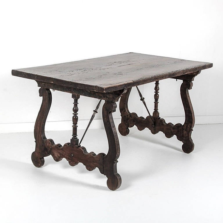 A rare 19th century small-scale antique Italian trestle table with wrought iron hardware and a rich original patina. A structurally sound and incredibly chic table with distressing typical of the age and use of the piece. A similar piece was shown