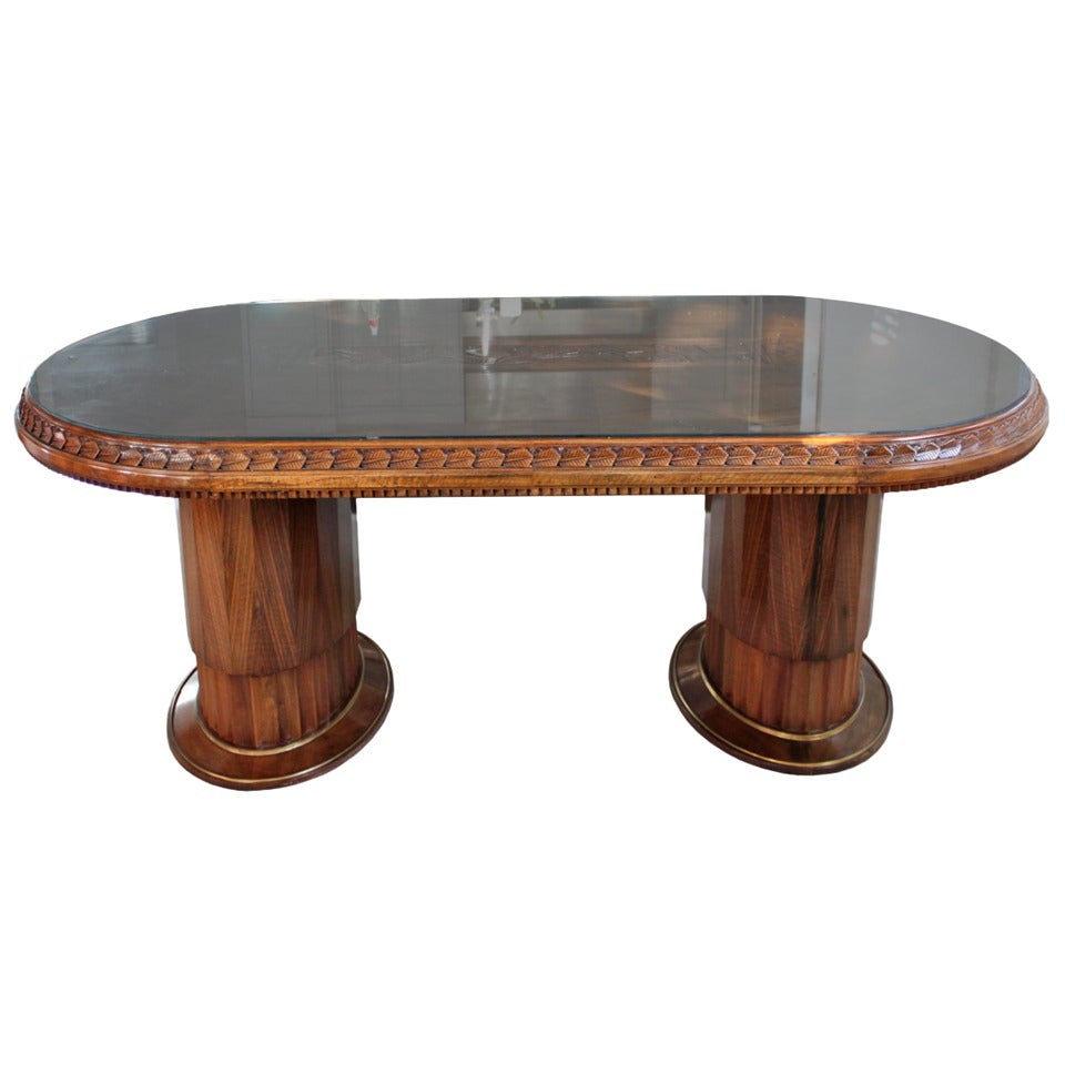 Carved art deco table attributed to famed designer Paul Follot. Walnut table top with foliate decoration and geometric detail on apron. Suitable for use as a desk or dining table. Originally fitted with an optional center leaf, not included.
