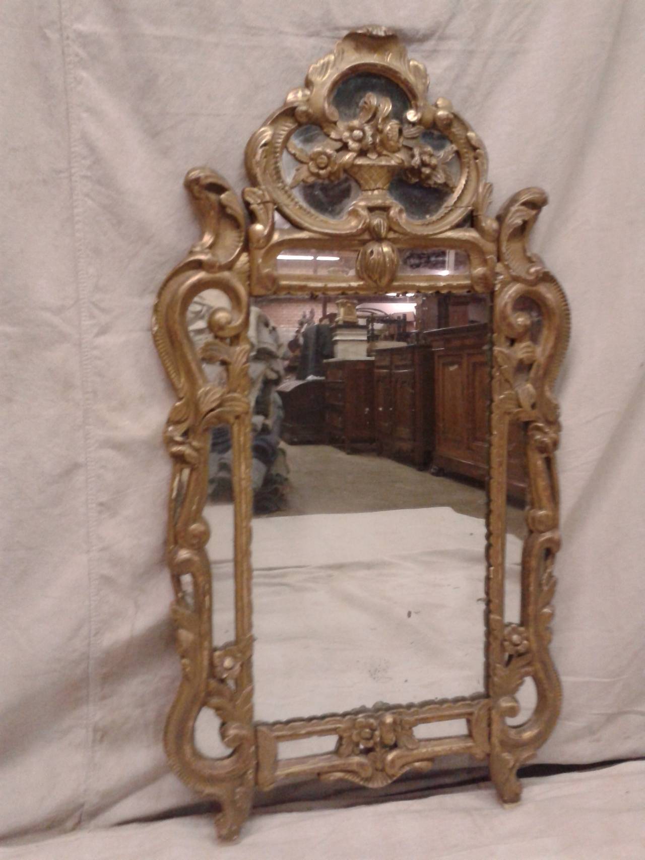 19th century, French Provençal mirror. The giltwood frame reveals its classical nature, with its carved, rounded arches.