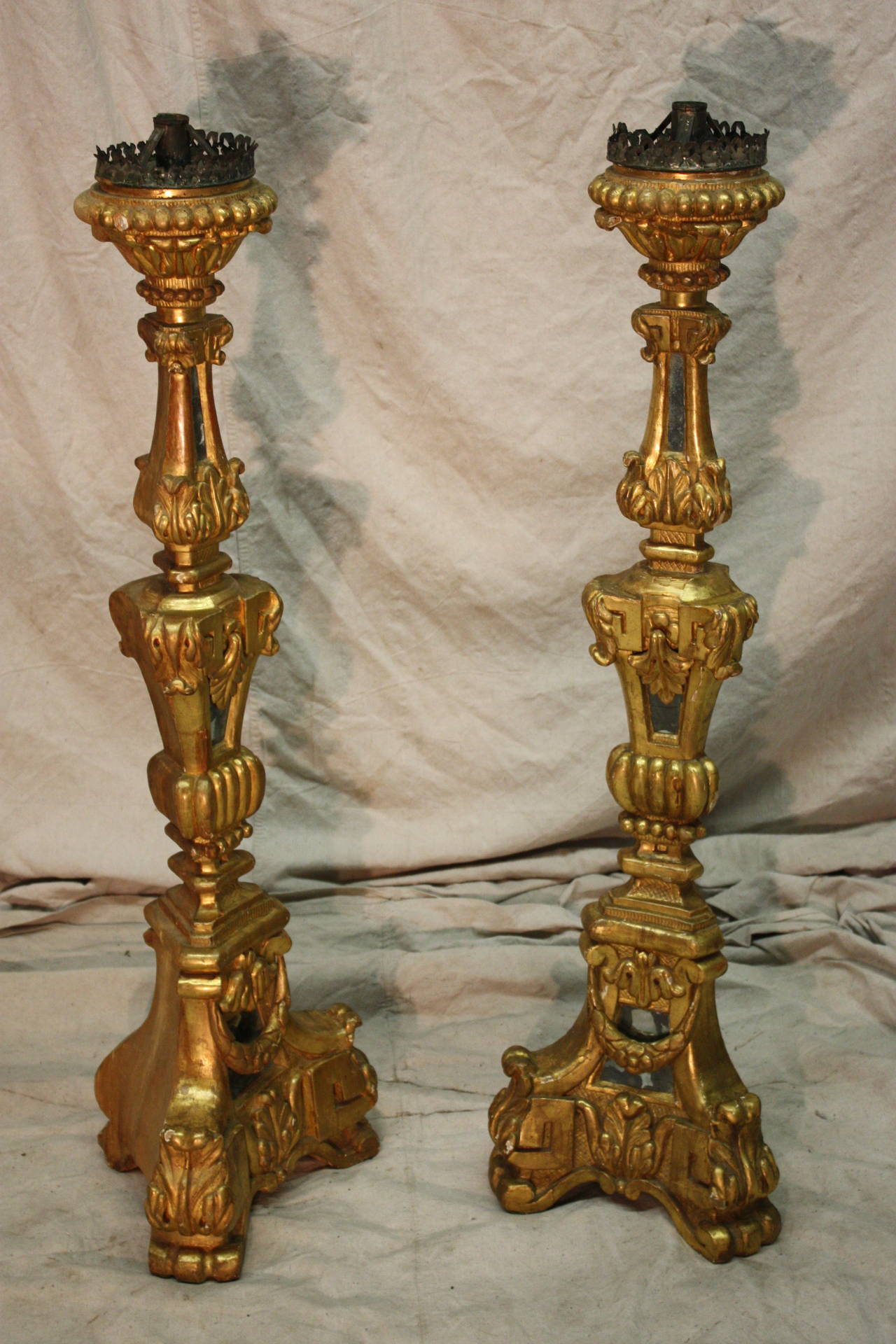 18th Century Italian Giltwood candlesticks. The candlesticks are recovered of gilt leaves and old mirrors.