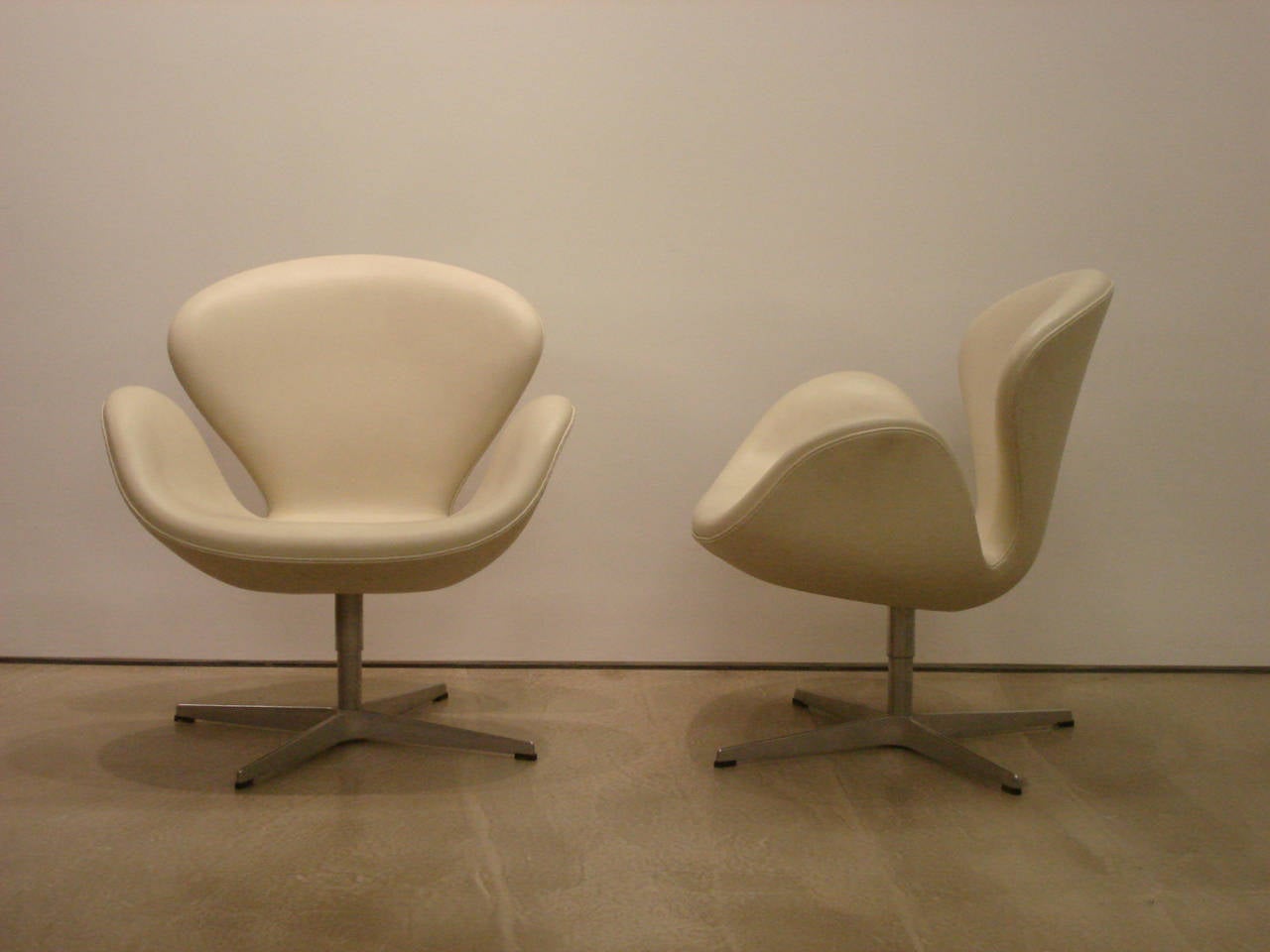 A pair of Swan Chairs in white leather by Arne Jacobsen. Made by Frits Hansen. Designed 1958. 

The 