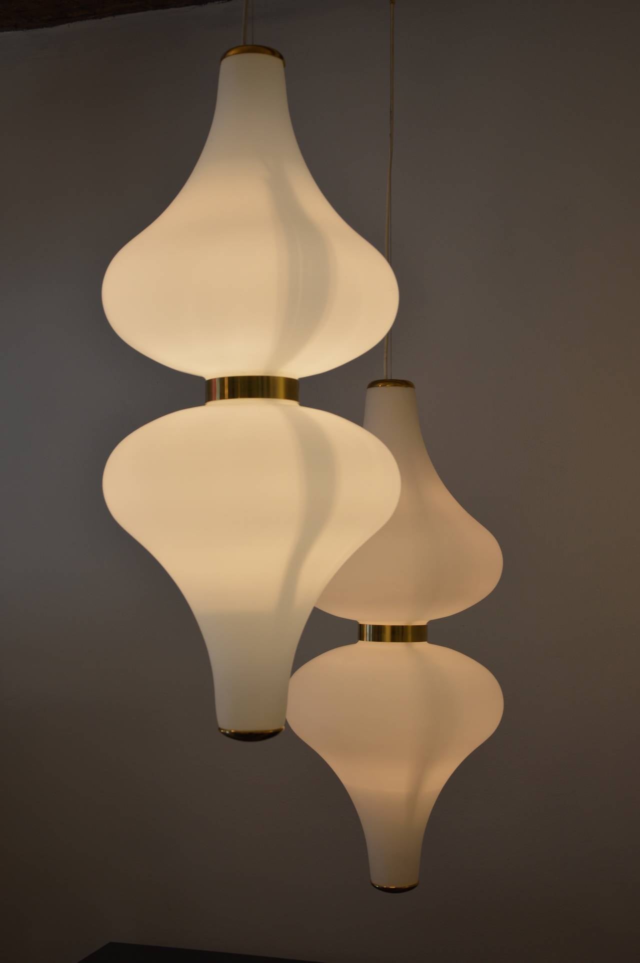 Pair of pendant lights by Stilnovo in white glass and brass