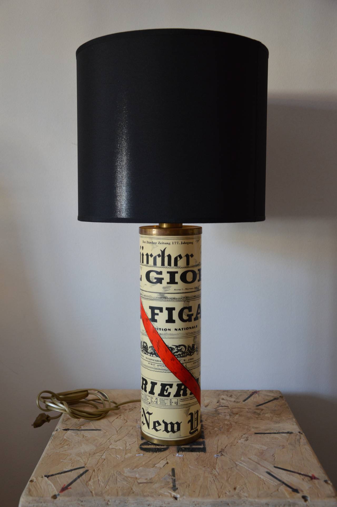 White Cream table lamp by Piero Fornasetti with decor of Press titles. 
Base is brass, black clothe lampshade golden inside. Signed Fornasetti Milano on the bottom. 
Dimensions : 
H : 43cm
Diameter : 10cm 
H lamp + lampshade : 64cm 
Diameter