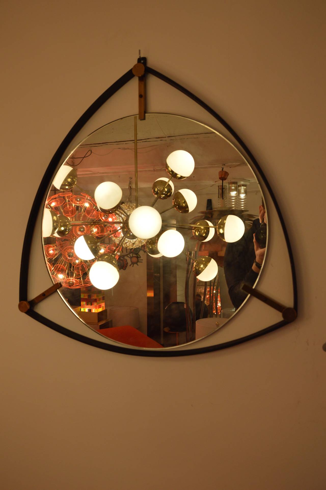 Italian triangular mirror with frame in steel and brass circa 1950. 
Measures : 
H : 64cm 
L : 64cm 
D : 2,5cm 
Diameter of the mirror : 50cm