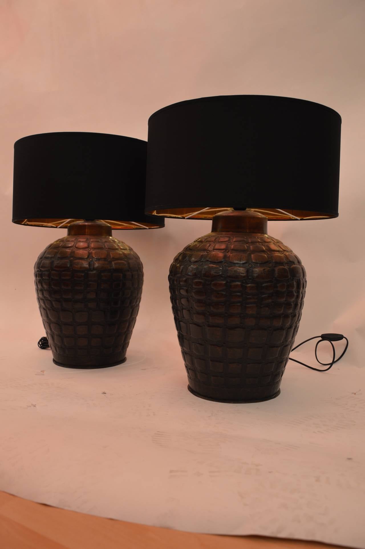 Pair of decorative table lamps in brass covered by a copper patina, and motive of animal skin like elephant. 
Measures :  H : 45cm  H + lampshade : 61cm 
Diameter max : 33cm  Diameter of the Base : 20cm 
Diameter of the lampshade : 43cm