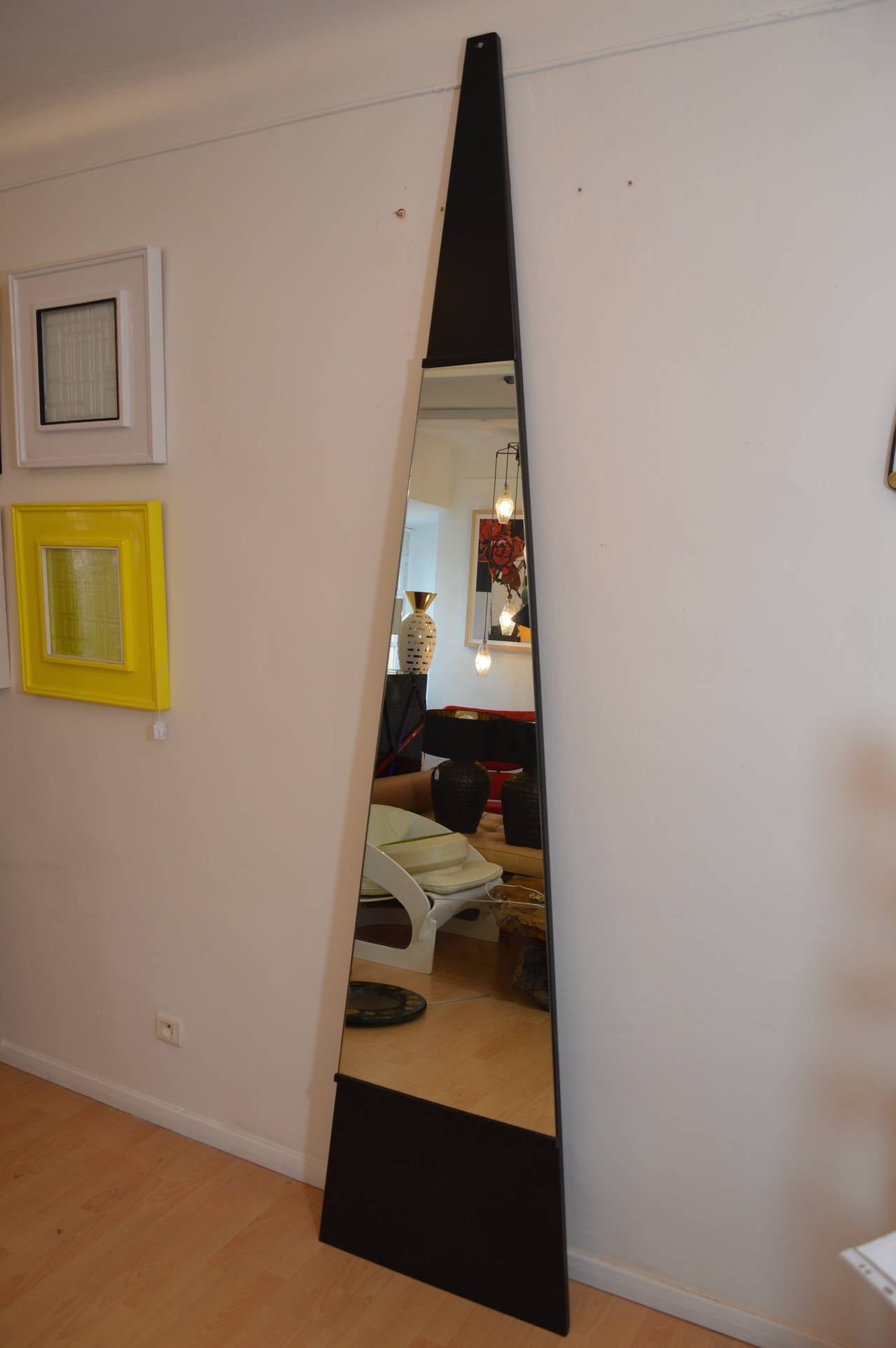 Important triangular mirror on a support in black painted steel. 
Italian work circa 1970.
Measures :  H : 252cm  L : 47cm  D : 3cm   L min : 6cm 
Measures of the mirror :  H : 150cm