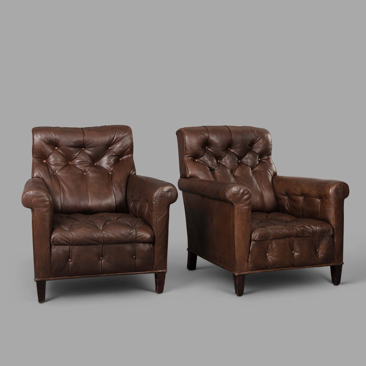Leather patina highly enhanced by the time for this pair of early 20th century tufted leather armchairs.

Few expert restorations to strengthen the leather.