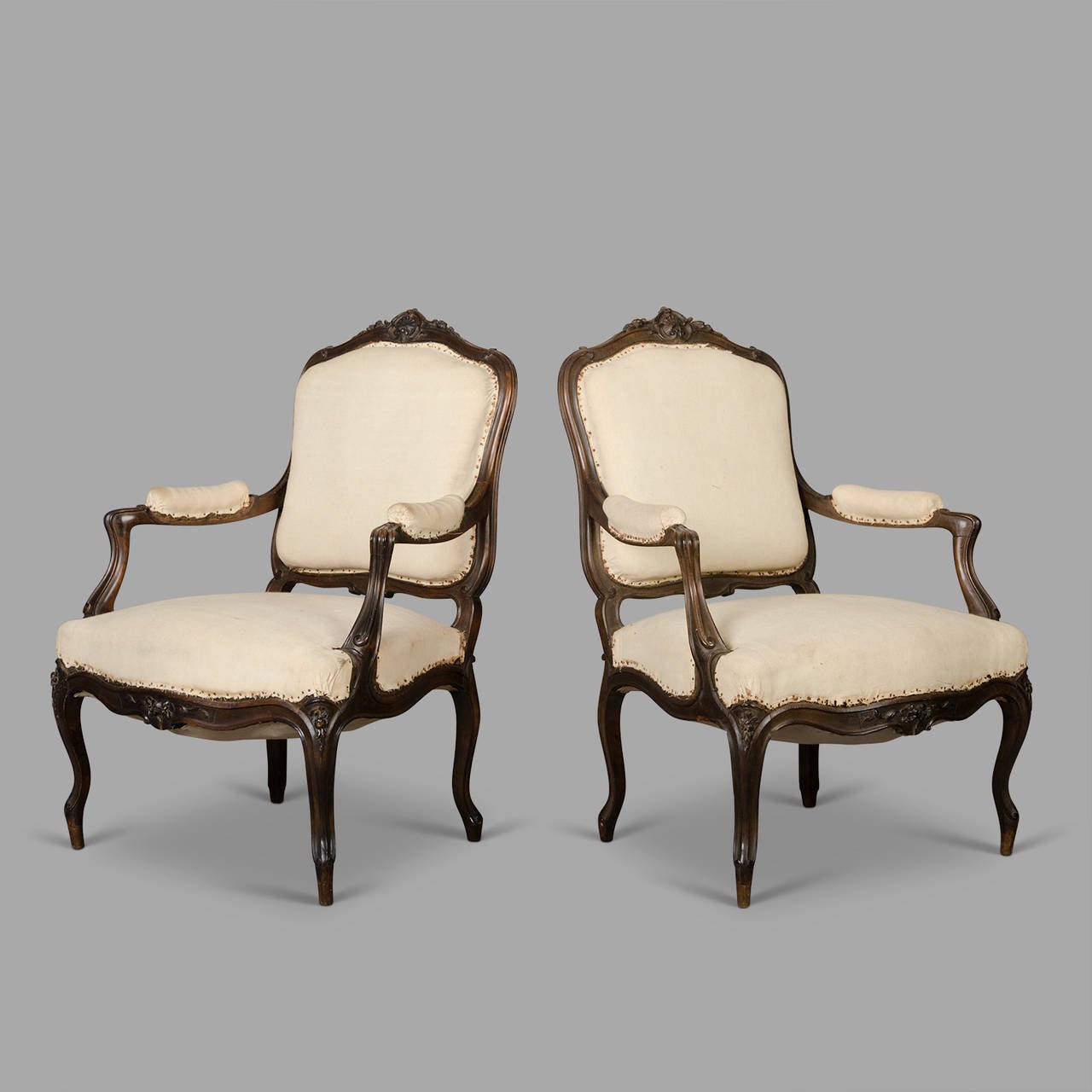 Pair of 19th Century (circa 1880) cabriolet armchairs with a fine carved decor enhanced with flowers and scrolls. Very good upholstery condition. Ready to be covered with new fabric.