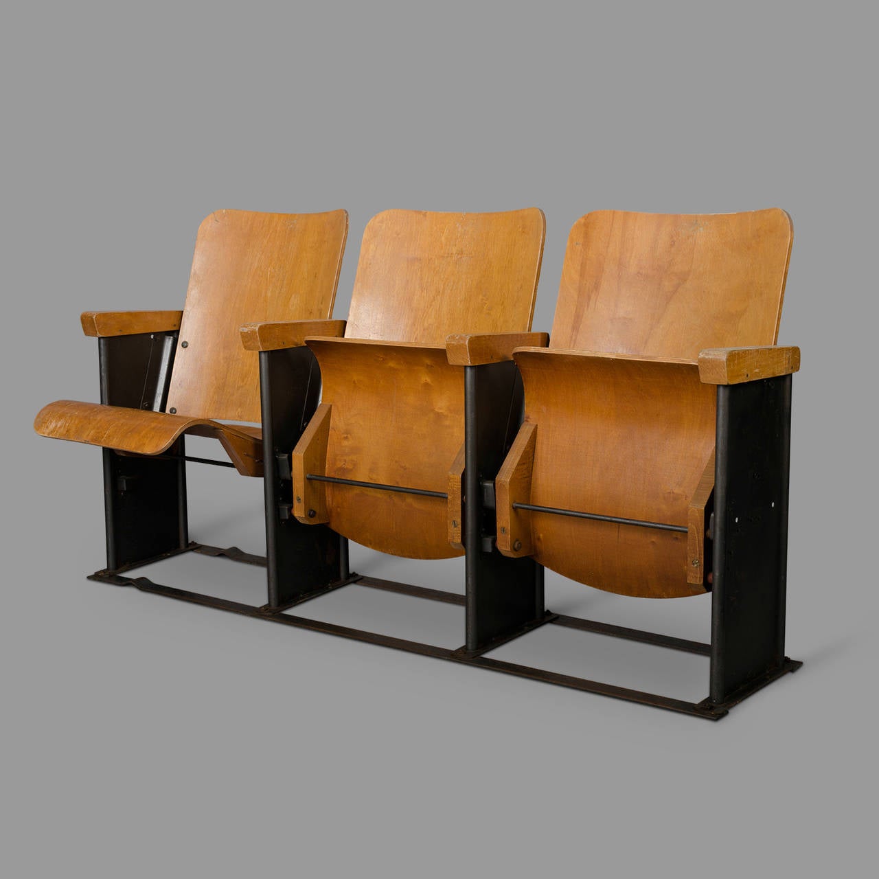From a military base, these three seats row wooden movie theater seats in molded plywood and bent sheet metal, are typical of the 1950s. Very stable, they do not necessarily require floor fixation unlike many models of the same style.

Three seats