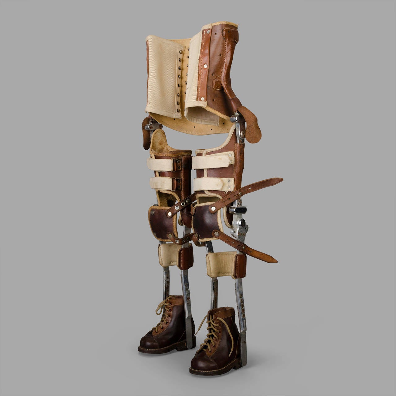 Composé d'une structure métallique et de pièces de maintien en cuir. Il est équipé de chaussures d'origine. Deux lanières de cuir manquent près de la partie protectrice du genou droit.