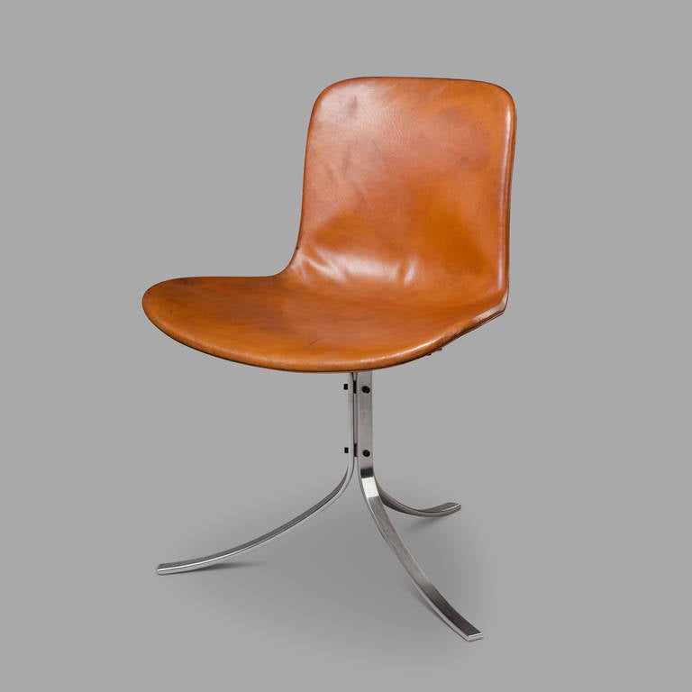 Edited by Kold Christensen Ejvind. Original logo affixed to the inside faces of the  three curved stainless steel feet. 

Leather patina enhanced by some traces of time and wear.