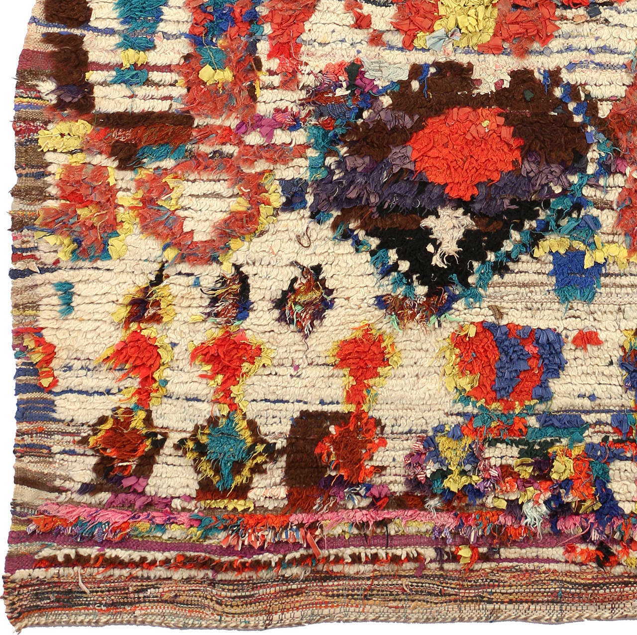 This Morrocan Carpet from the region of Ourika depicts a fascinating variety of different colors and pattern. The bright white background is filled with vibrant  forms in pink, red, green, yellow, brown, red, purple and blue. Some seem to be human