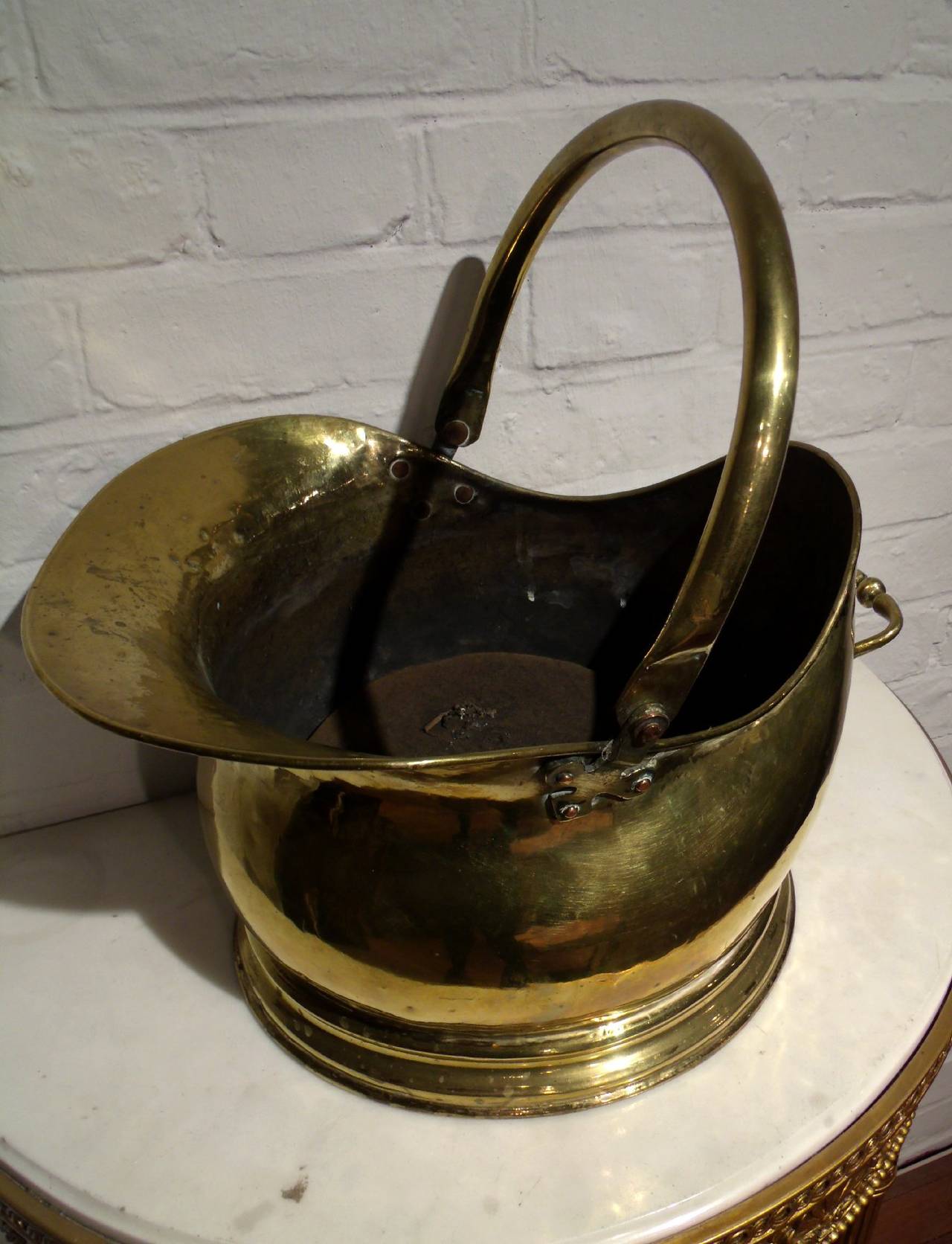 A very attractive Victorian brass coal scuttle bucket with hinged handle, circa 1880. The bucket also has a side handle and wide pouring lip. It measures 15 in – 38 cm wide by 13 in – 33 cm deep with a height of 16 in – 40.6 cm in height.