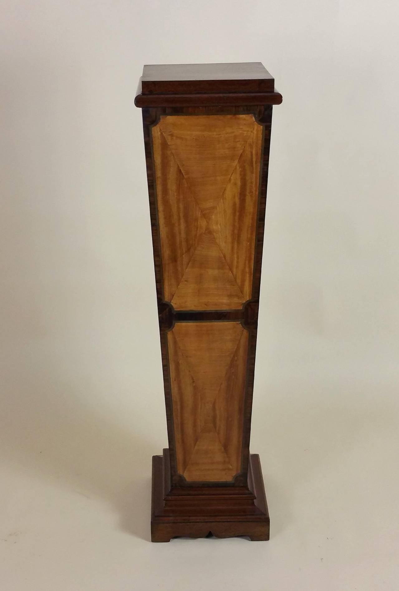 This lovely Edwardian Sheraton Revival mahogany tapered pedestal is inlaid and bonded with Satinwood and Rosewood on the front and both sides. The simple but elegant design of this pedestal would allow it to work with several different traditional