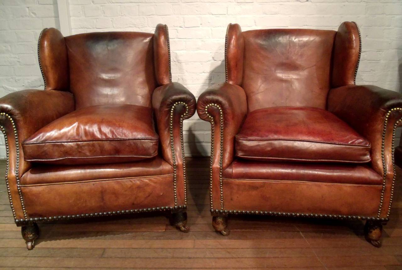 This very handsome pair of late Victorian gentlemen's leather club chairs
feature the original leather upholstery over an oak frame on ceramic castors. The chairs are extremely comfortable with plump separate leather seat cushions and a wing chair