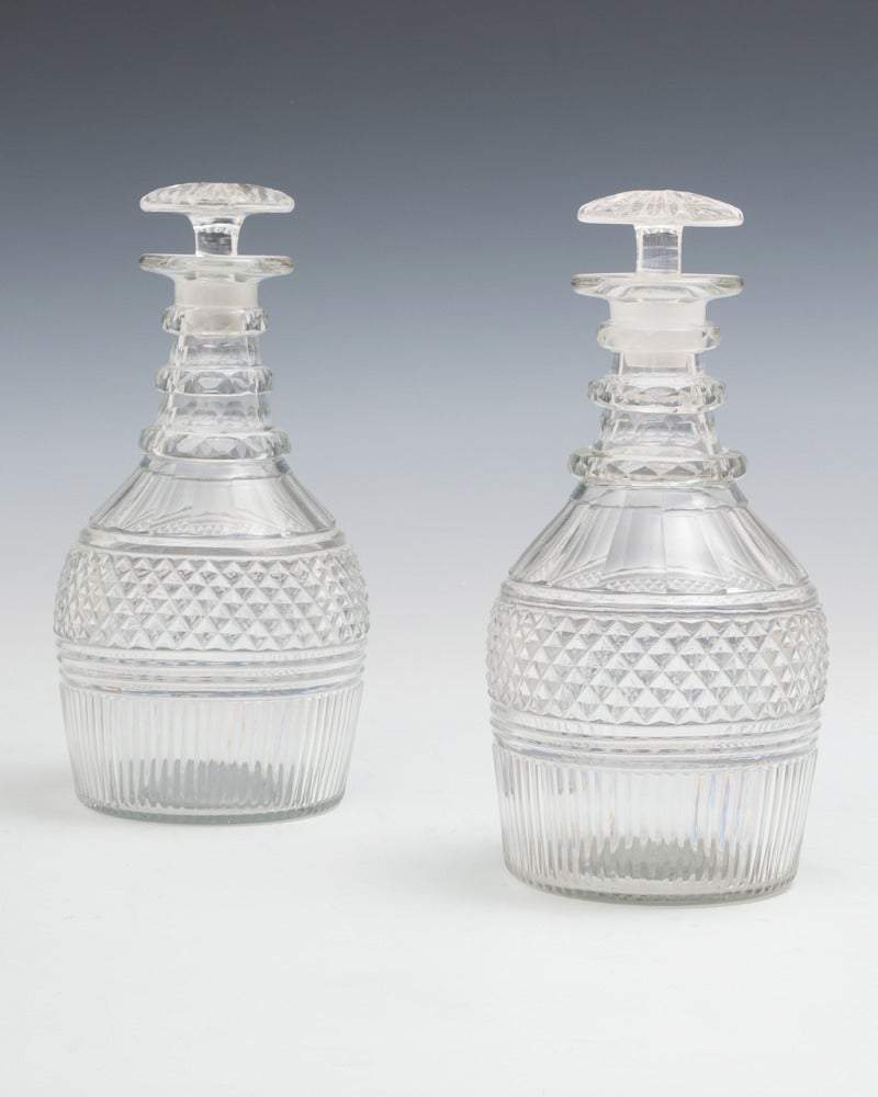 A pair of flute step and diamond cut Regency decanters with mushroom stoppers.