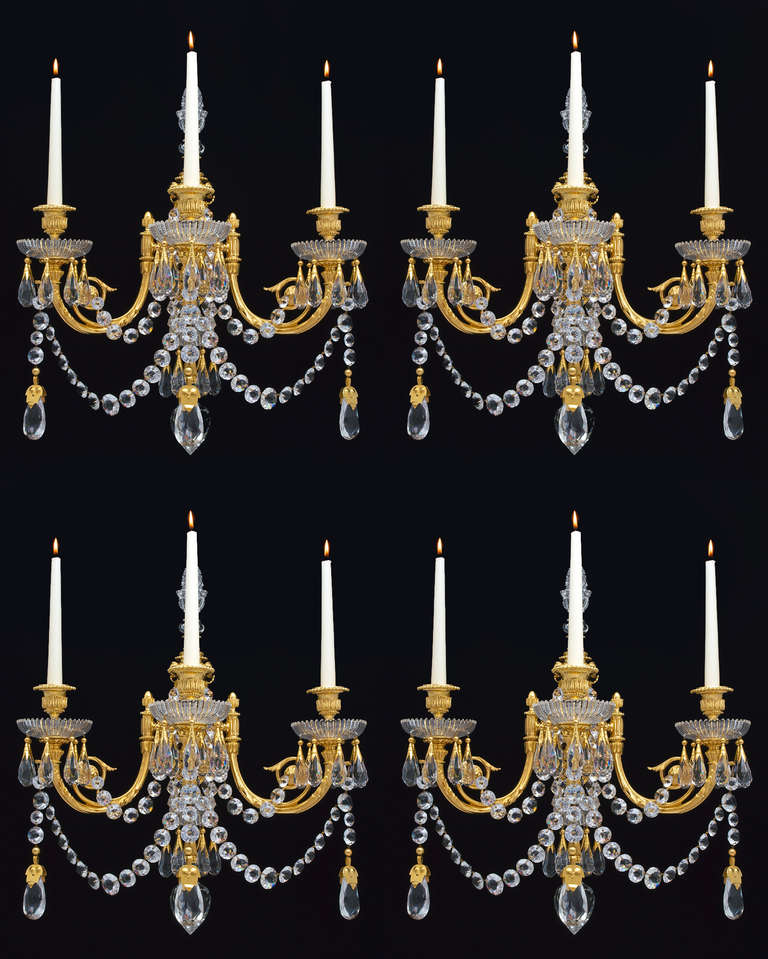 An important set of four early Victorian ormolu-mounted and cut-glass three light wall lights .The main ormolu ring surmounted by lapidary cut finial and under canopy the top centred by a diamond cut finial the three ormolu candle arms with