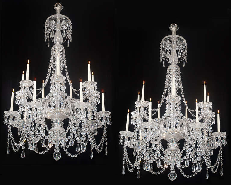 A fine pair of fourteen-light cut-glass chandeliers the main baluster stem surmounted with drop hung stem pans terminating with a larger top canopy, the mitre cut receiver bowl with lower canopy and lapidary cut finial, the receiver plate supporting