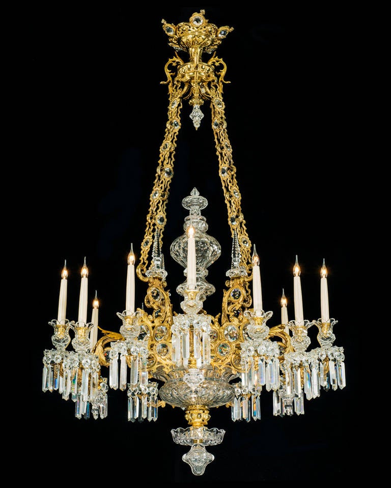 The top corona with facetted cut jewels this suspending four chain with corrinsponing insets these supporting a richly cut bowl and four foliate three branch candelabra each with scalloped edged facetted-glass drip pans candle nozzles and prismatic
