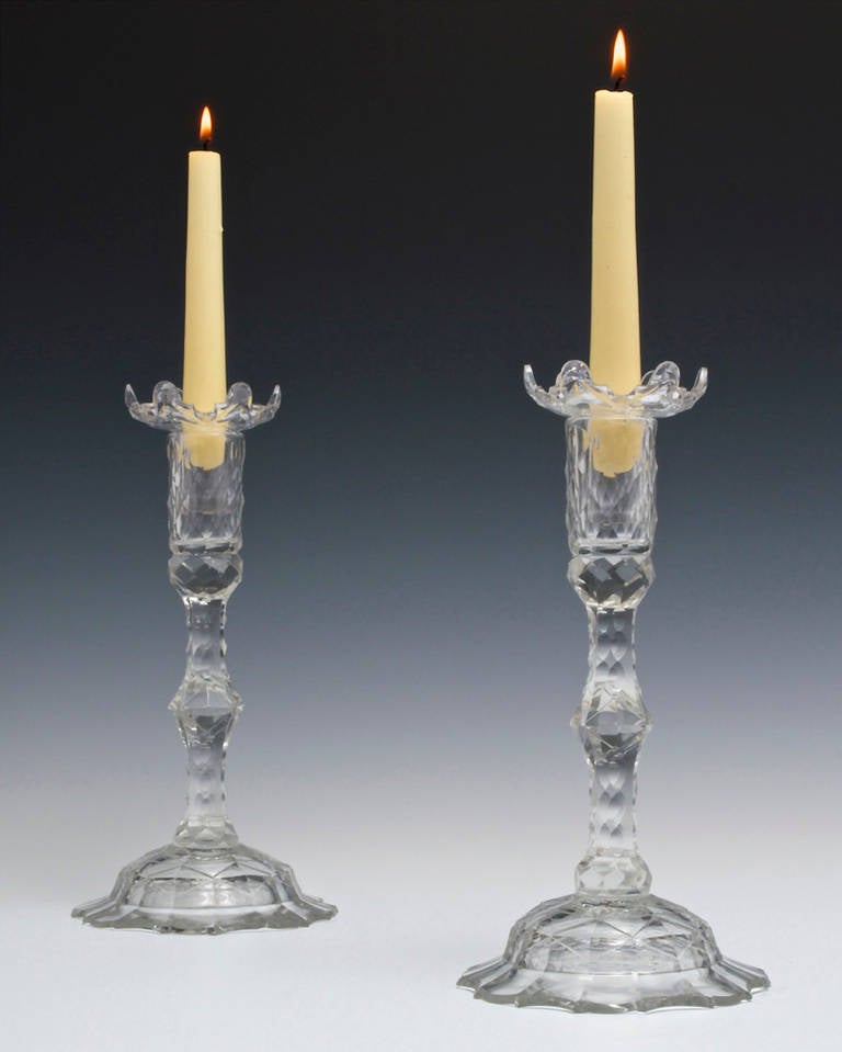 A fine pair of Georgian candlestick the flat cut foot supporting nitched cut stems and scale cut tubes fitted with vandyke savels.