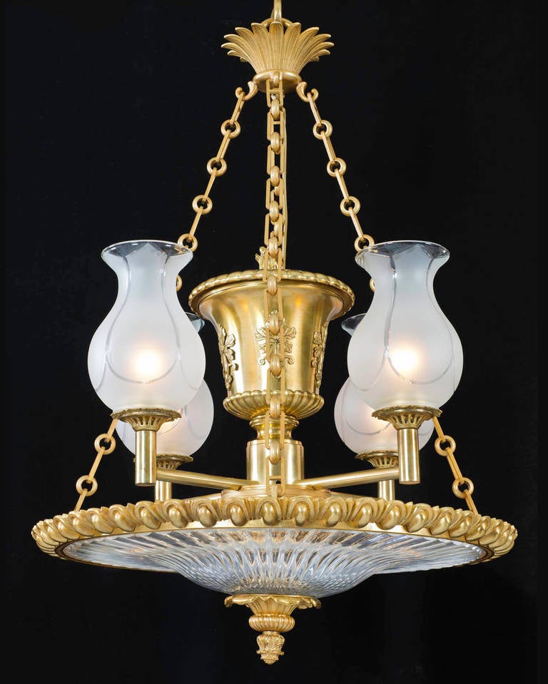A fine Regency period ormolu and glass dish light the arched and pillared ormolu band this surmounted with a pillar cut-glass dish and ormolu corona with pine cone finial this suspended on four chains with Classic palm corona, the central urn