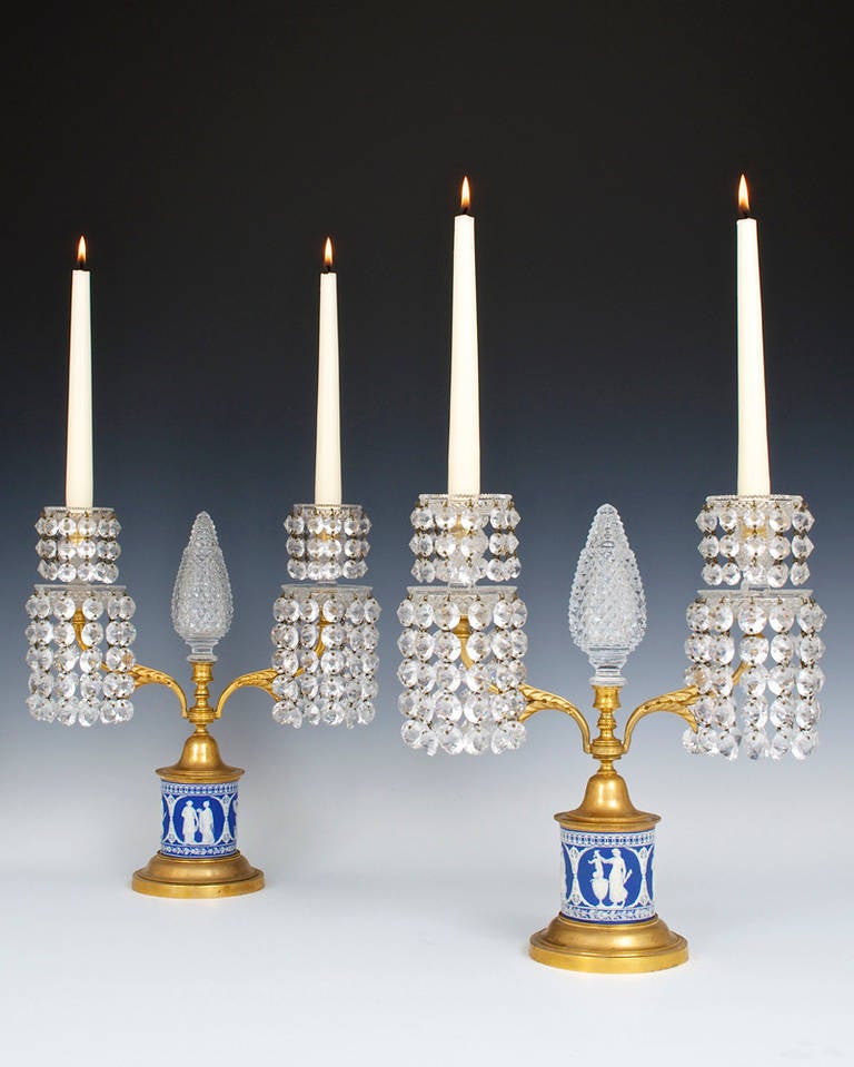 A fine pair of English Regency two-light jasper-ware base ormolu-mounted candelabra the round blue, white drums decorated with neo-classical sense of classic Wedgwood type, the drum surmounted by an ormolu dome and knurled ring supporting leaf