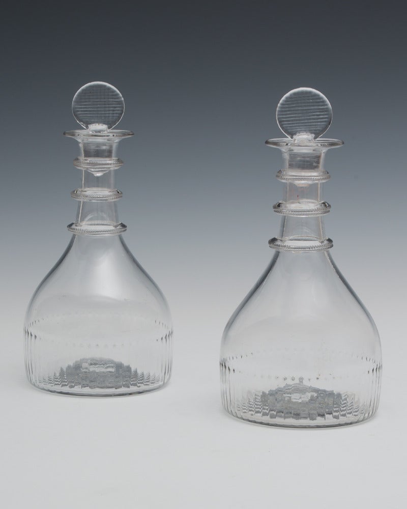 A marked pair of decanters the base pressed CORK GLASS CO with applied rings and grid pressed stoppers.