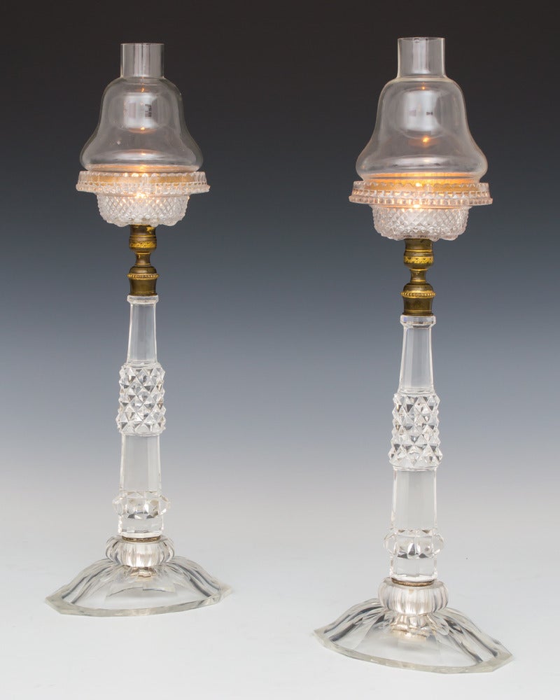 A pair of late Victorian cricket lights the slice cut foot mounting diamond and slice cut stems these supporting moulded candle dishes and plain shades.