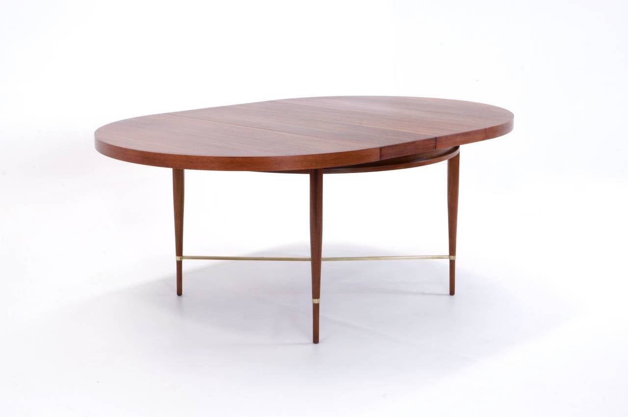 Beautiful Paul McCobb Irwin collection dining table. Expertly refinished mahogany with brass cross stretchers. Begins as a 48