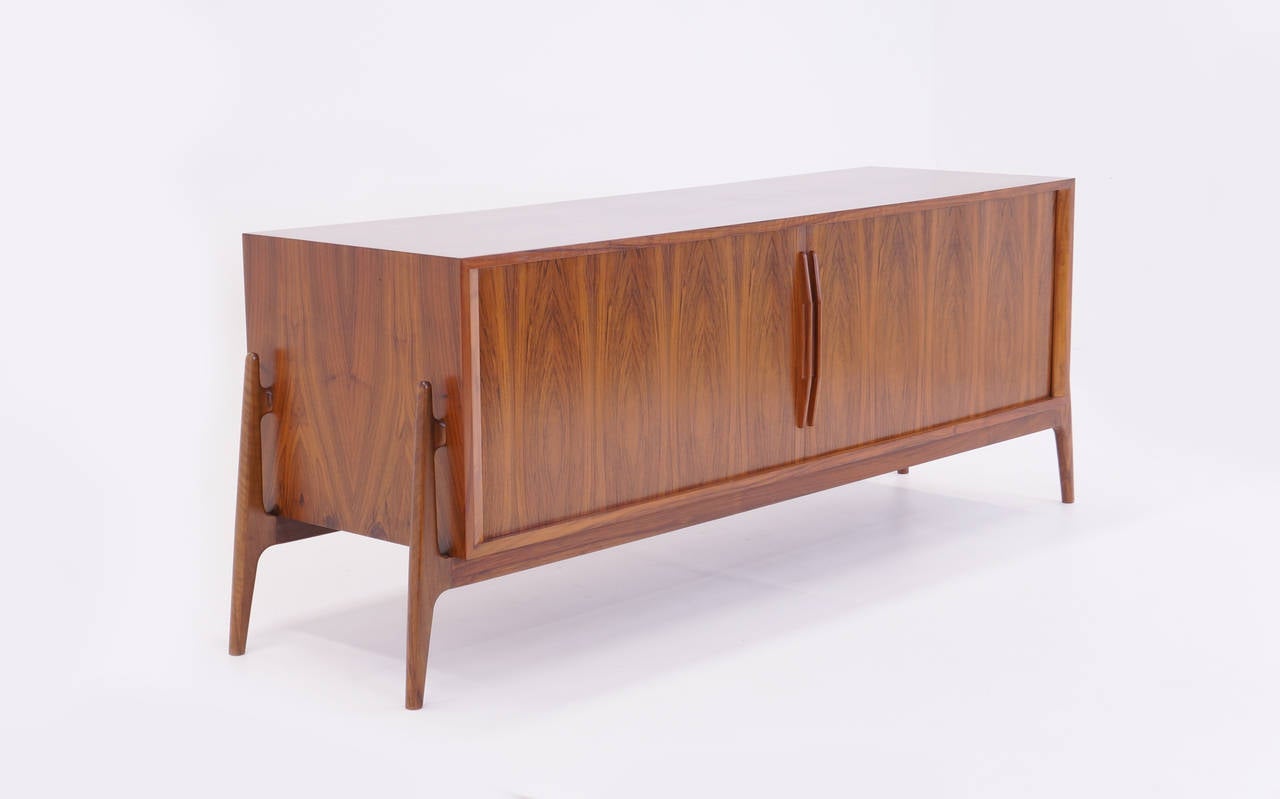 Stunning Brazilian rosewood tambour door credenza attributed to Finn Juhl. Given the beautiful rosewood grain and the size (see dimensions), this piece makes a striking statement.