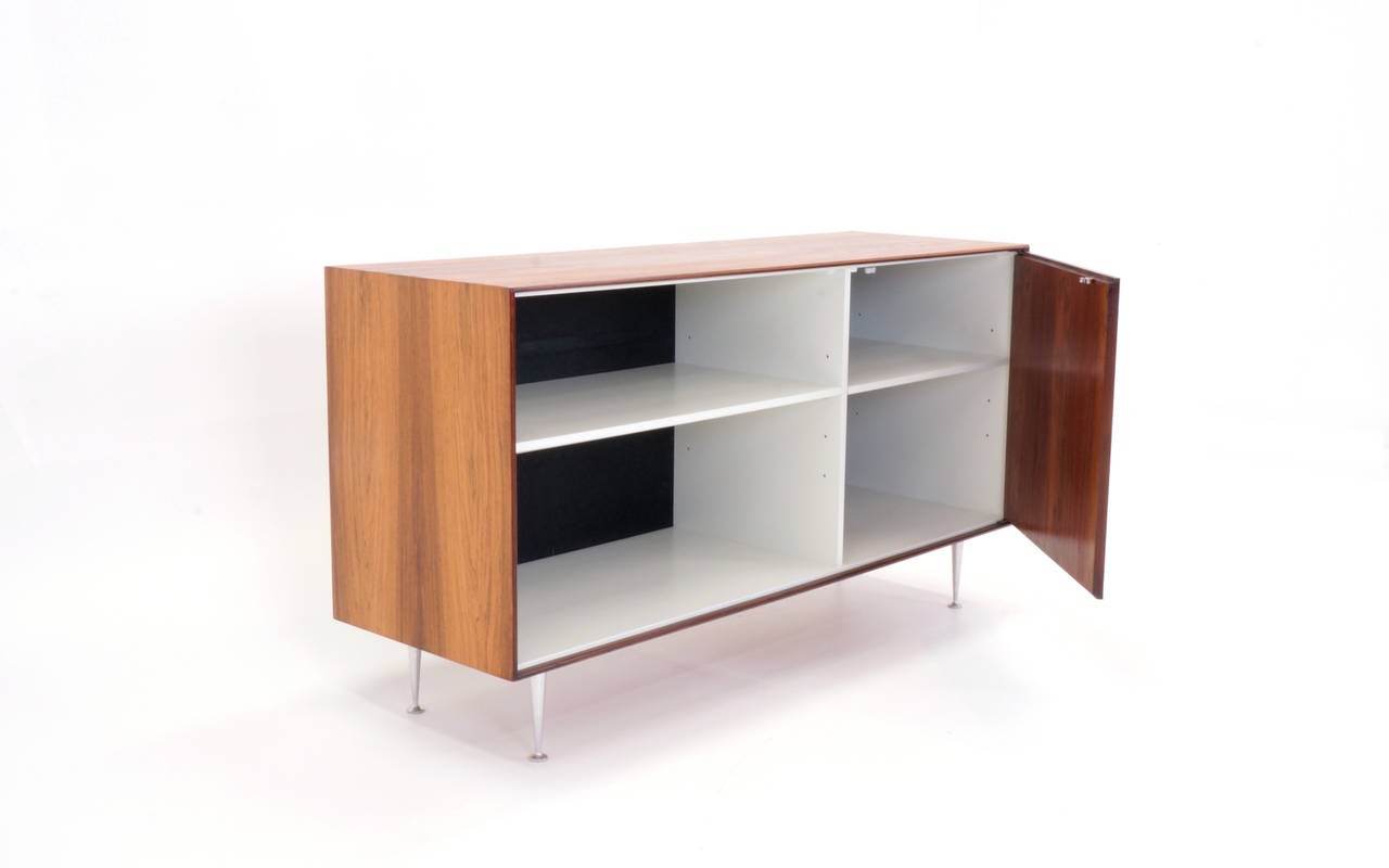 Stunning George Nelson thin edge cabinet in Brazilian rosewood. Open adjustable shelf on one side and door on the right. This would make an amazing audio or tv components cabinet. Maintains original cast aluminum legs.