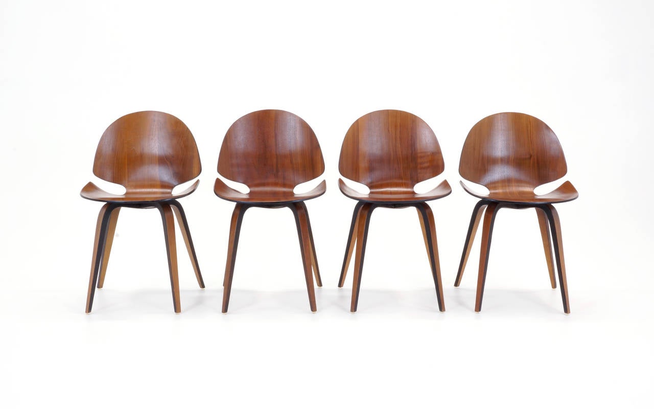 Often attributed to Norman Cherner, this set of four sculptural bentwood dining chairs are designed by George Milhauser for Plycraft. These chairs are all original and in amazingly good condition.