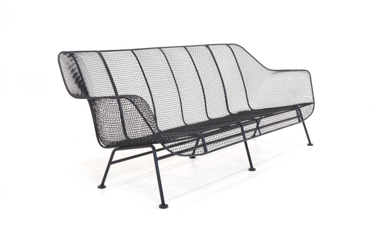 This Russell Woodard iron and woven wire sofa was never used outdoors and has just been professionally media blasted and powder coated in satin black. Can be used indoors, outdoors, patio.