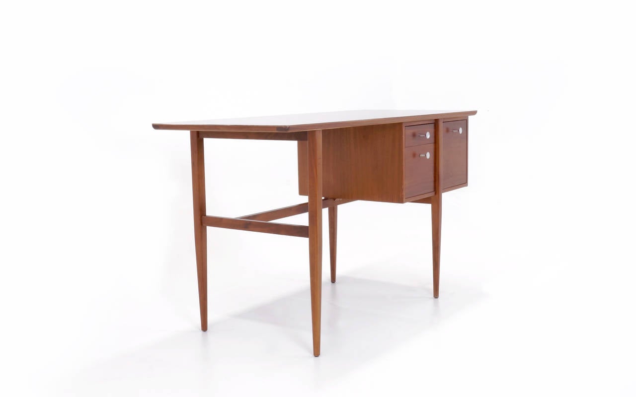 Excellent Glenn of California desk designed by Kip Stewart.  Great asymmetrical design.  Walnut with a white laminate top.  All original, including hardware.  Very rare version.